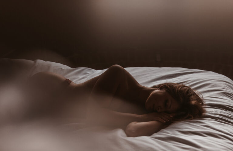 femme couchee dans un lit à la lumière naturelle